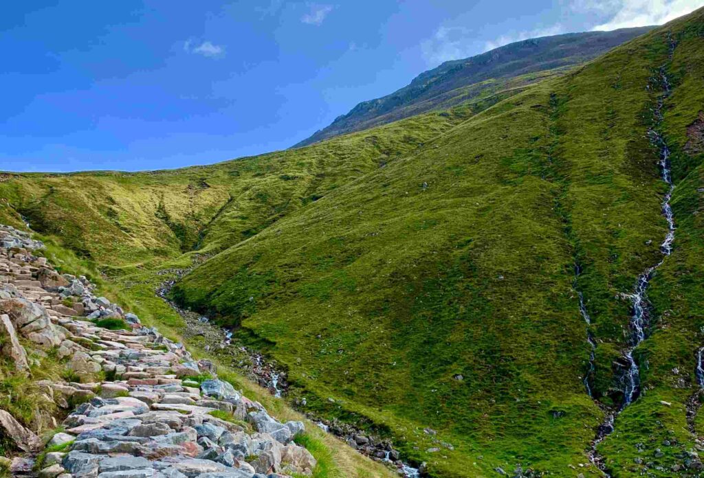 A photo of the most famous trail on Ben Nevis called the Pony Track with stone steps and gorgeous green grass