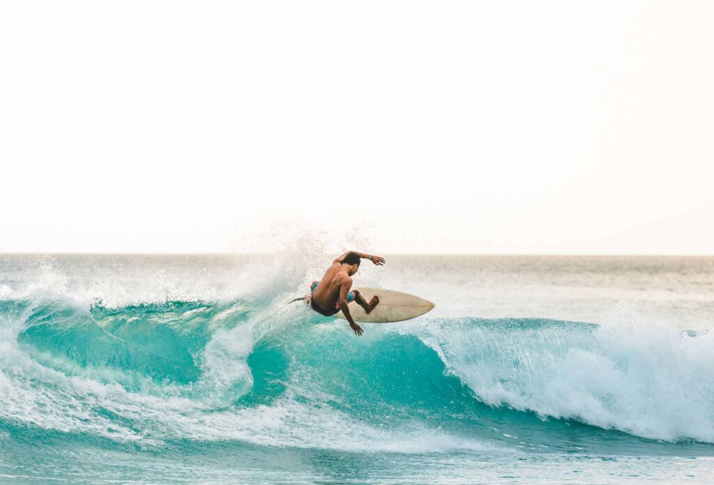 surfer performs dangerous stunt on blue wave