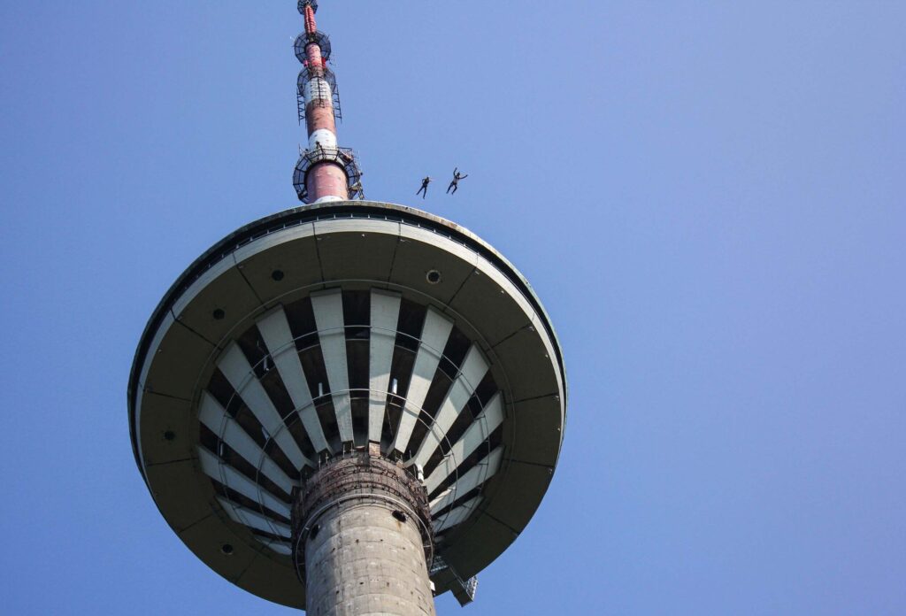 2 basejumpers jumping from a very high antenna downward