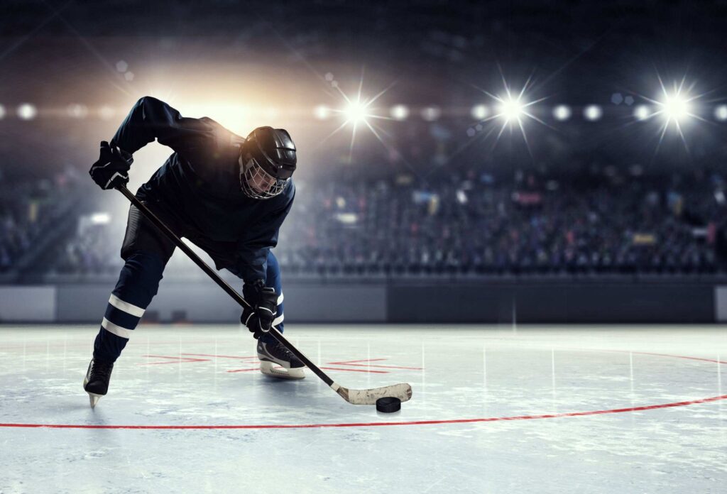 a picture of a hockey player in a blue uniform leading the puck
