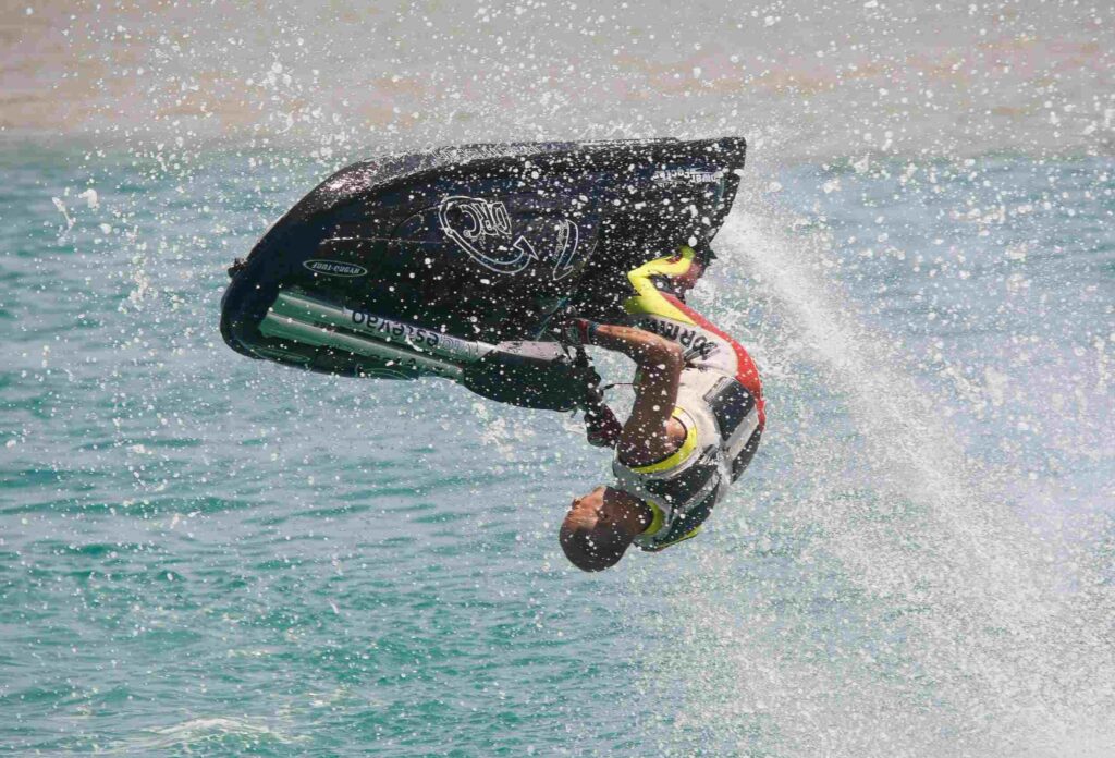 man does a somersault on a jet ski creating a splash