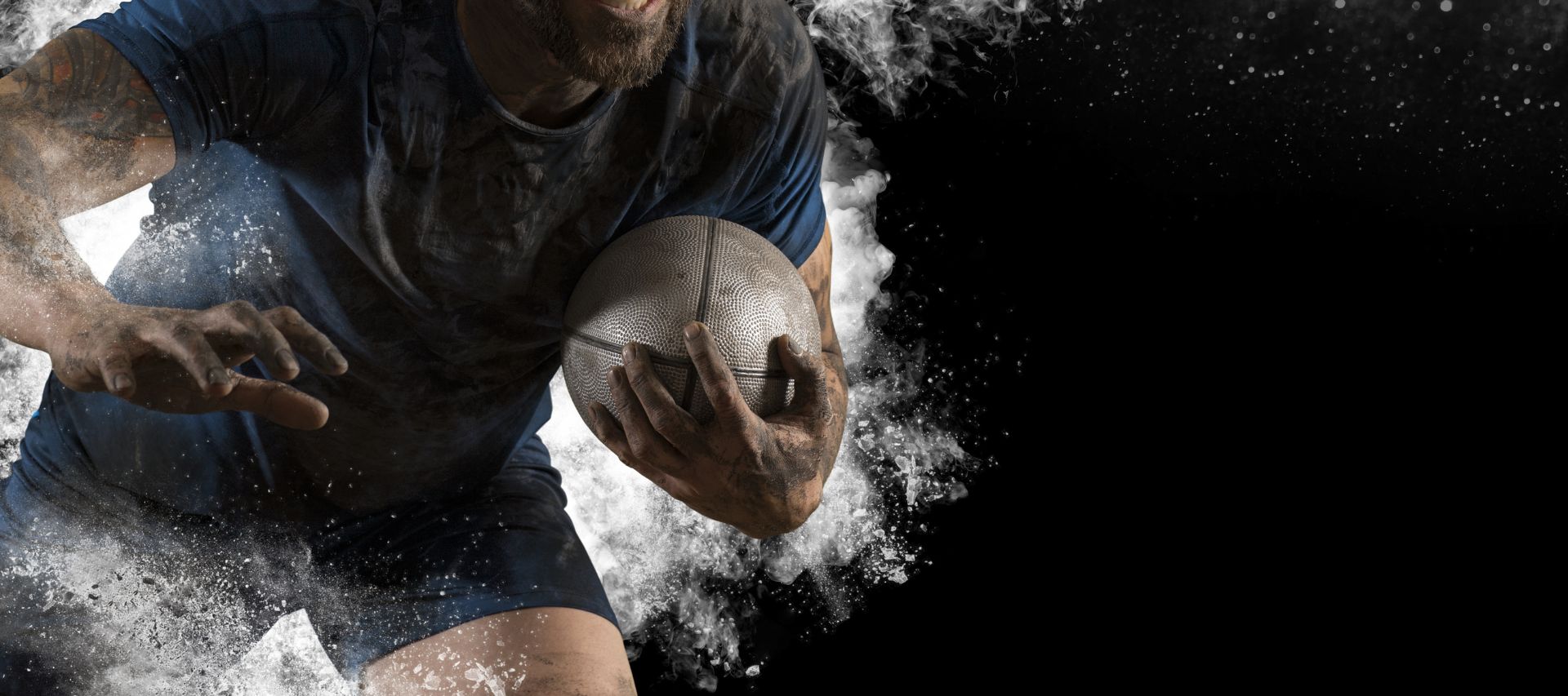 picture of a rugby player with a tattoo on his arm running with the ball on a black background