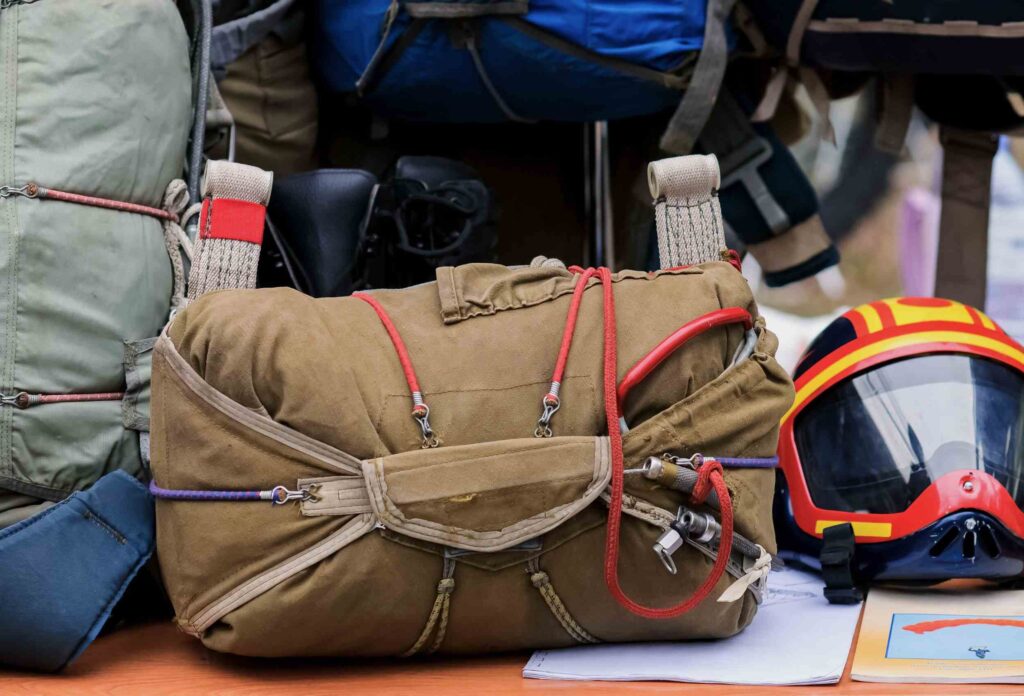 a photo of a skydiver's outfit with several parachutes and a red helmet