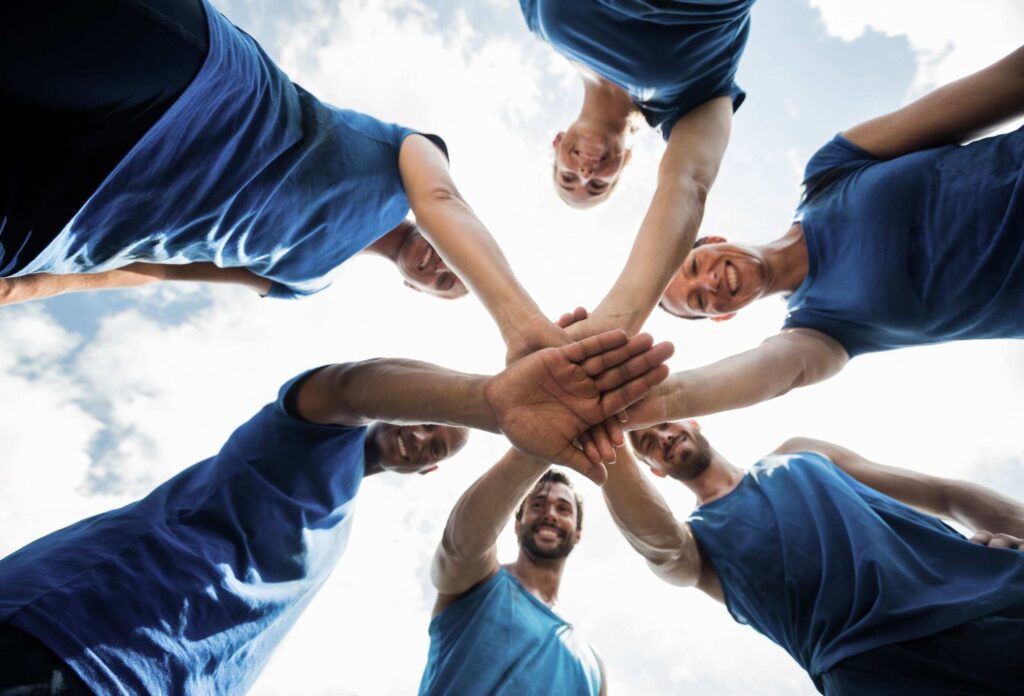 athletes in blue jerseys put their hand on their arm