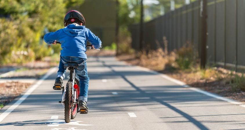 a child riding a bicycle on a cycle path