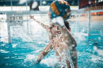 a man throws the ball into the goal at water polo