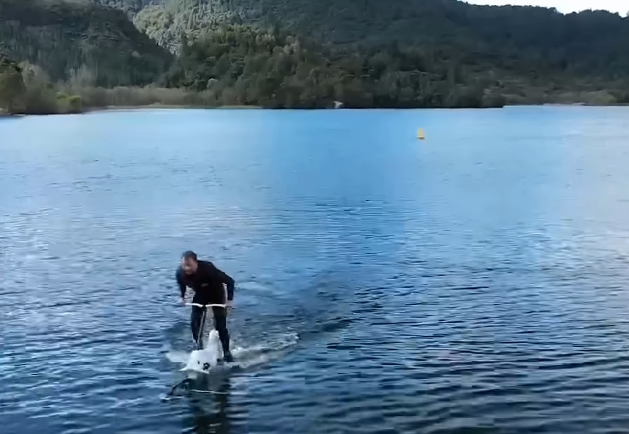 a man riding a water cycle on the water